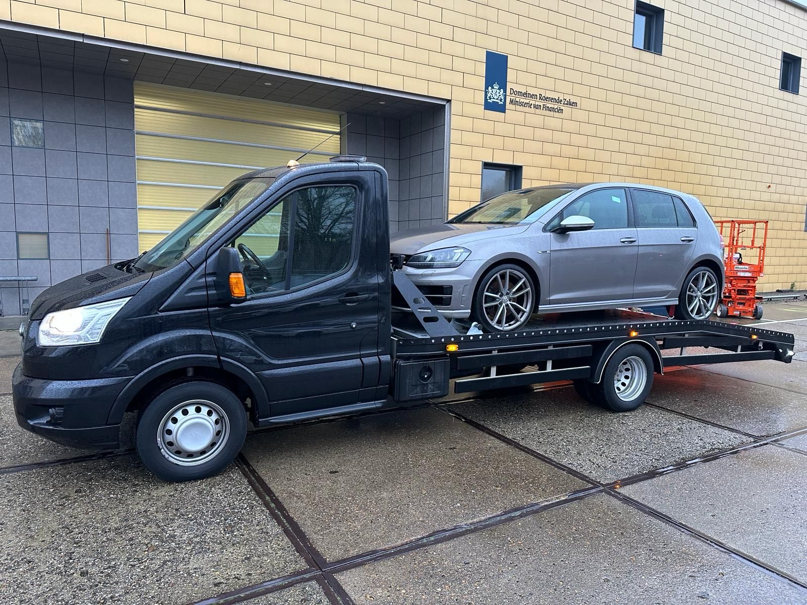 Grijze Volkswagen Golf op de oprijwagen, klaar om naar de garage te rijden