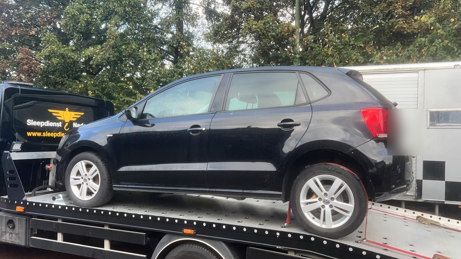Wielen van een personenauto vastgezet met rode wielbanden op de oprijwagen