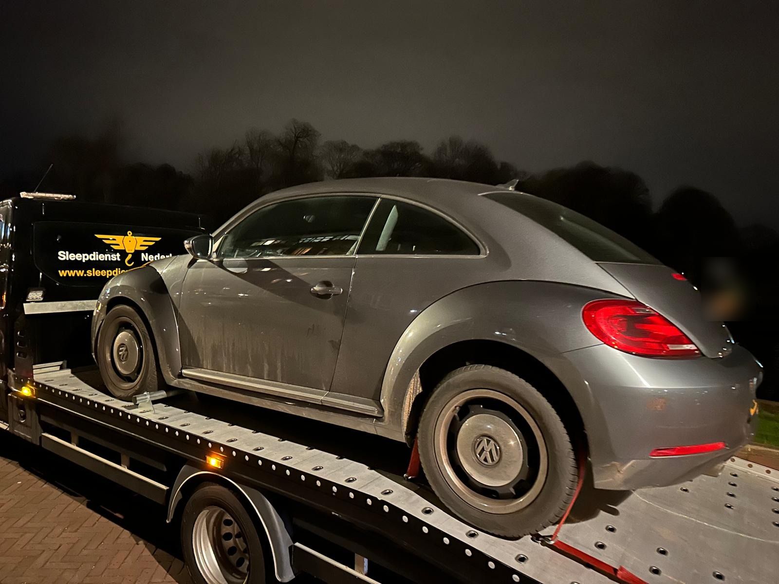 Grijze Volkswagen Beetle 's nachts op de oprijwagen